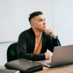 Man sitting at a desk with a computer, deep in thought about starting over with affiliate marketing