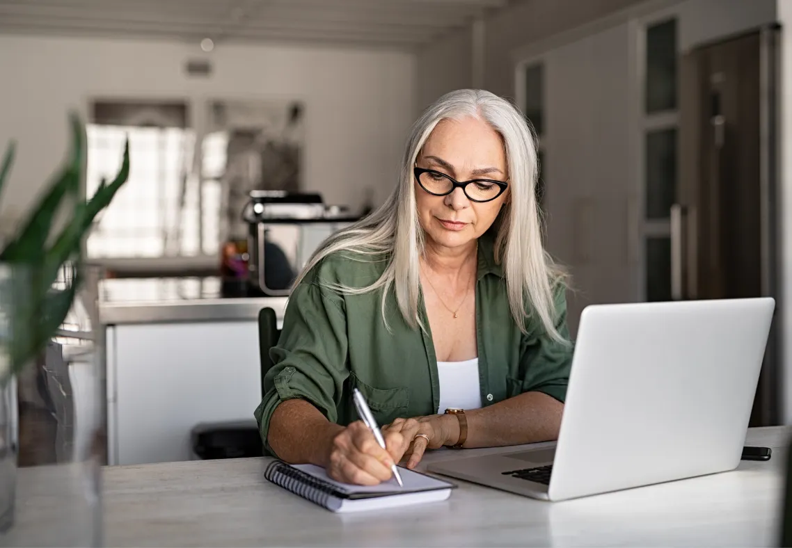 Beginner blogger working from home writing on laptop.